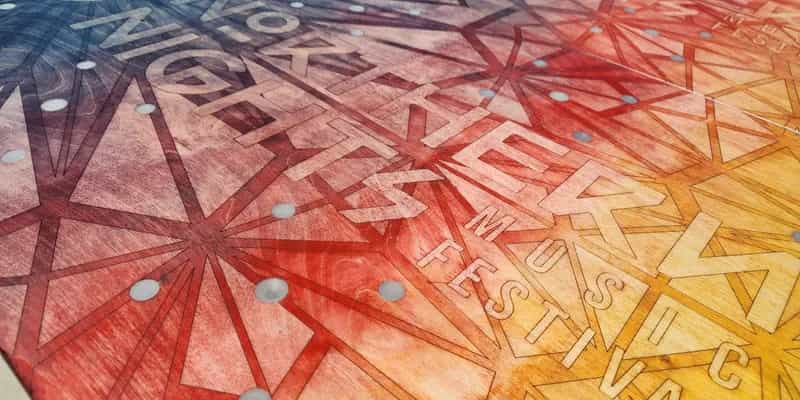 Detailed view of the intricate laser-etched design and colorful stained wood finish on a custom YoreBoard cornhole surface.