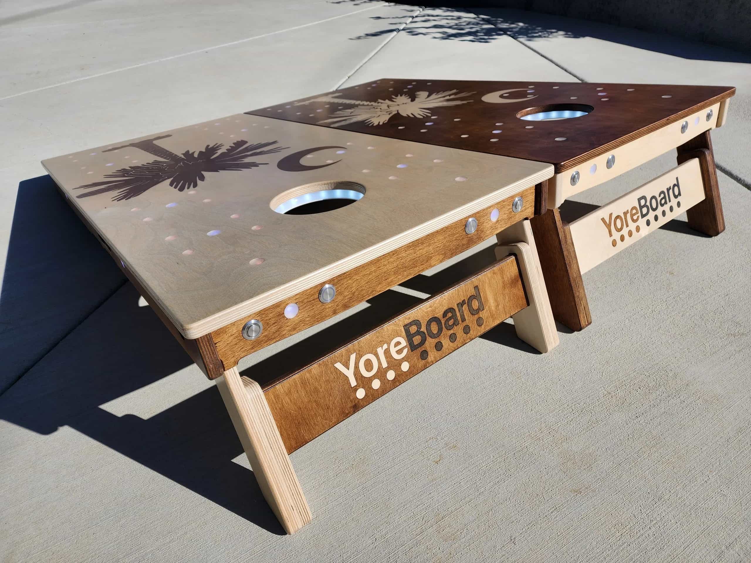 Detail shot of YoreBoard cornhole board legs, featuring a durable, two-tone hand-stained wood finish and the distinctive YoreBoard branding.