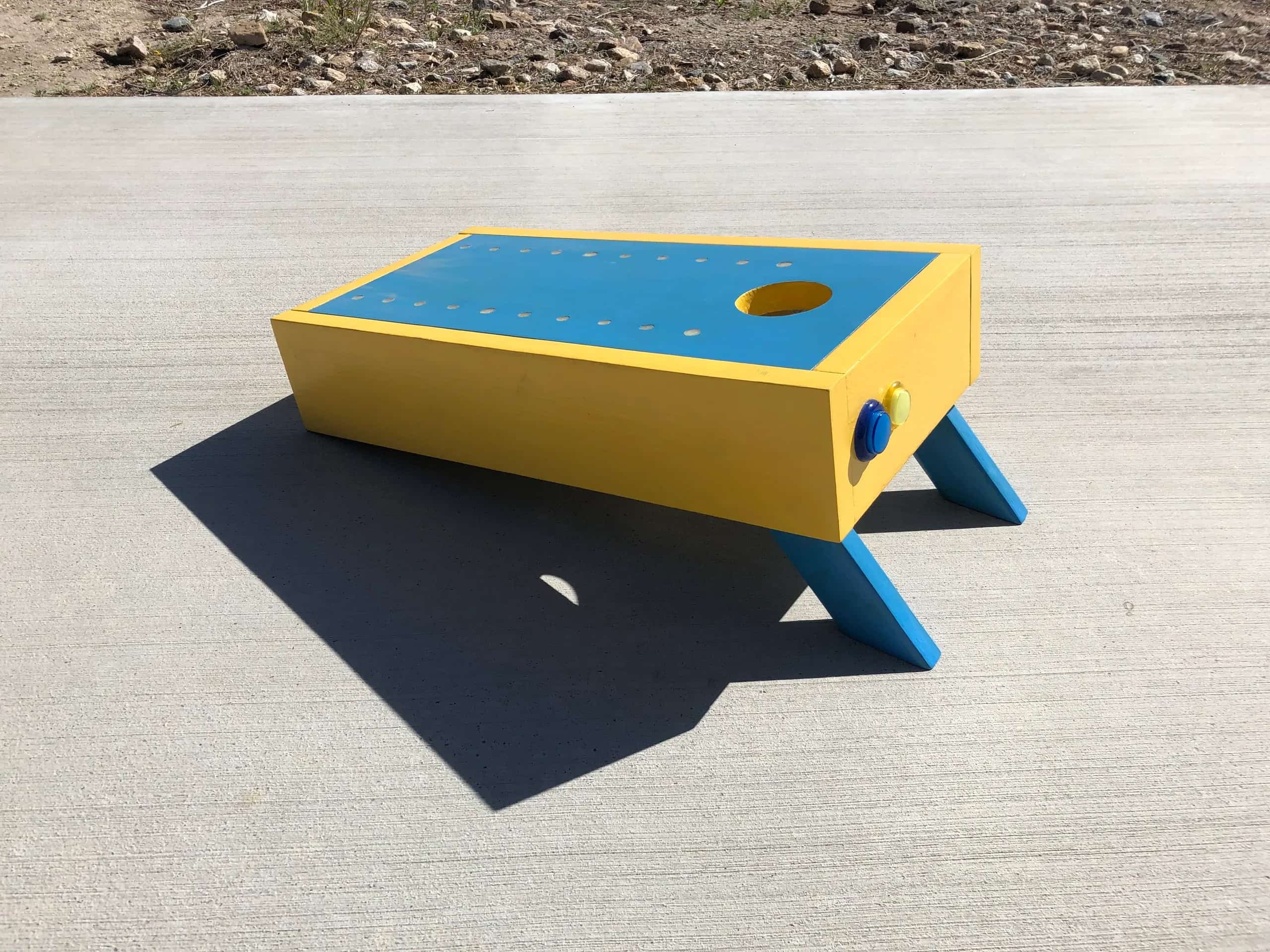 Early YoreBoard prototype in yellow and blue, showcasing design with Scoring LED holes and score control buttons.