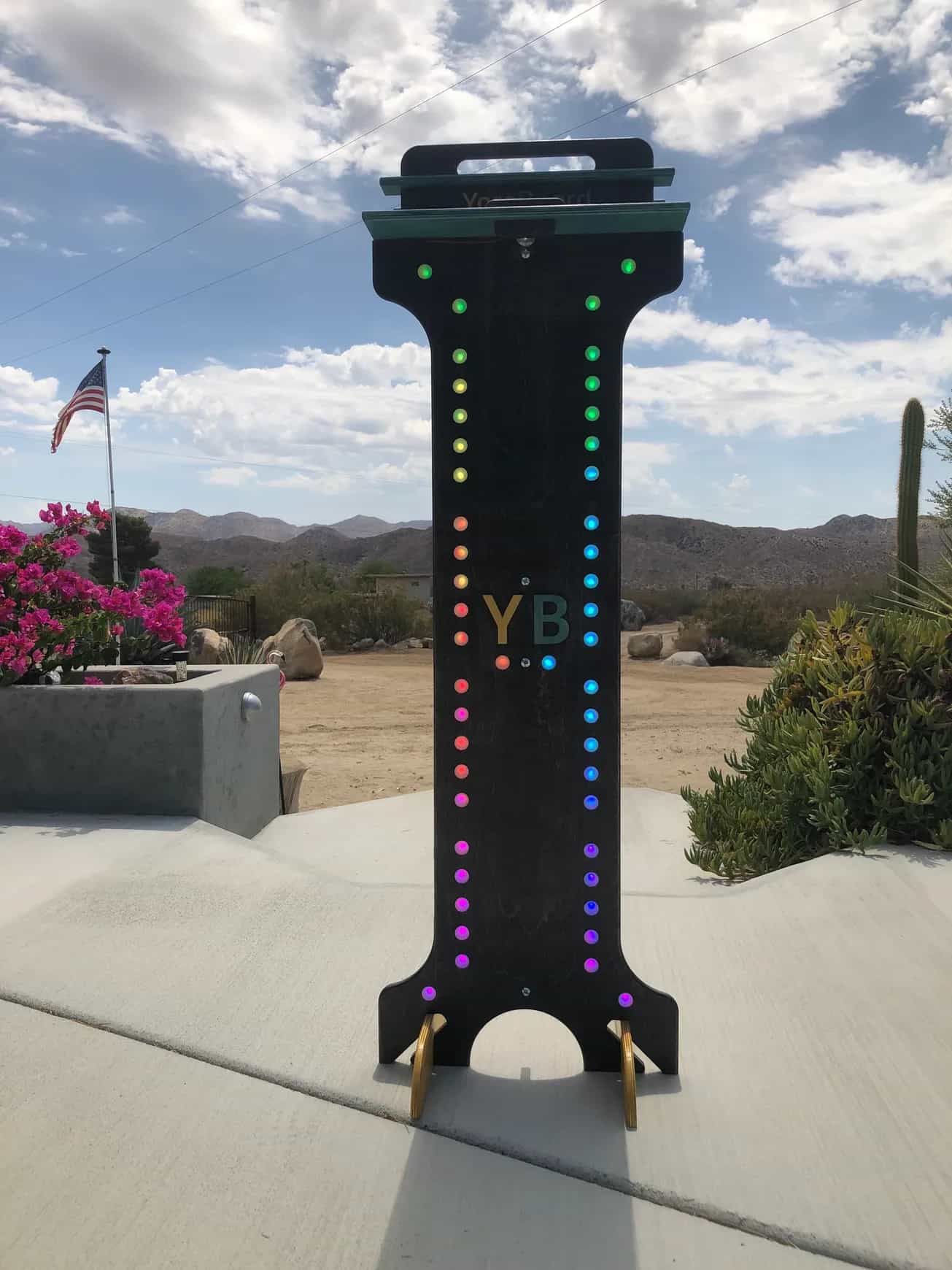 YoreBoard score tower showcasing visible multi-colored Scoring LEDs and the 'YB' logo, set outdoors in daylight.